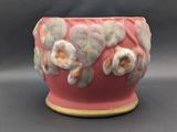 a pink vase with white and yellow flowers on it