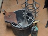 a metal bucket with tools on the floor next to it