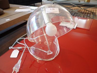 une table rouge sur laquelle est posée une lampe en verre