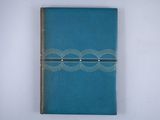 a blue leather journal with a spiral design on the cover