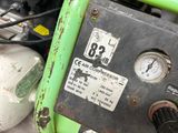 a close up view of a green machine with a gauge