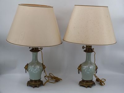 une paire de lampes en forme de vase bleues, rehaussées de touches dorées et dotées d'un abat-jour beige