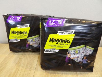 two packages of nigans diapers sitting on top of a wooden table