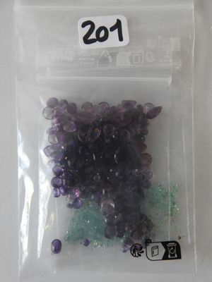 a bag of purple and green beads on a table