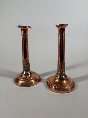 une paire de bougeoirs en cuivre ancien sur fond blanc