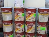 plusieurs seaux remplis de nourriture posés par terre à côté d'une pile de cartons