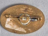a gold plate with a pin on it on a table