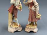 paire de figurines en porcelaine représentant un homme et une femme tenant des fleurs
