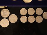 several silver coins sitting in a blue case on a black surface