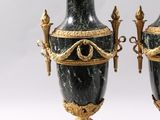 two black vases with gold decorations on them