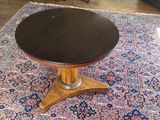 a table with a black top sitting on a rug