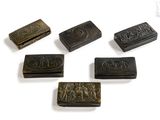 six pieces of carved metal on a white surface with a white background