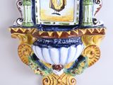 a clock on the wall with a painting on it