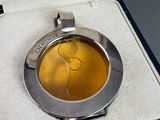 a silver box with a silver watch inside of it