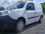a small white van parked in a gravel lot