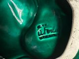 a close up of a green vase with a white base