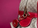 a close up of a purse with a red handle