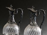 une paire de vases anciens en verre plaqué argent, posés sur une surface grise