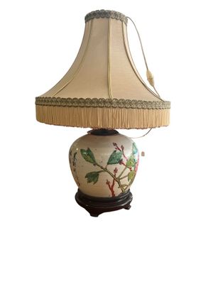 a lamp that has a bird on it on a table