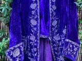 une photo d'une veste violette accrochée à une clôture en bambou