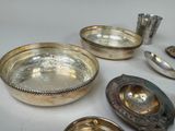 many silver dishes and spoons sitting on a table