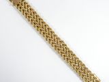 a close up of a gold bracelet on a white surface