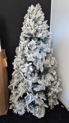 a white christmas tree and a brown bag on the floor