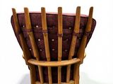 a wooden chair with a red cushion on it