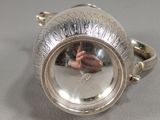 a silver ring with a reflection of a person in it