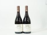deux bouteilles de vin posées sur une table blanche