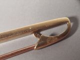 a close up of a gold pin on a table