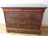 a wooden dresser with marble top on a hard wood floor