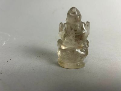 une image représentant une petite figurine en verre représentant un Bouddha