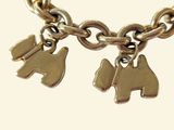 a gold bracelet with two dogs charms on it