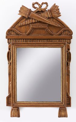 un miroir ancien en bois orné d'une sculpture représentant un oiseau sur le dessus