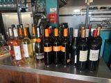 bottles of wine are lined up on a counter in a bar