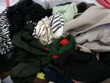 a pile of clothes that is sitting on a bed