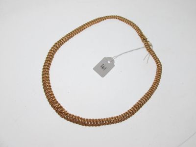 un collier muni d'une étiquette, posé sur une surface blanche