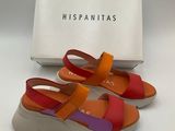 une paire de sandales orange et violettes avec une boîte
