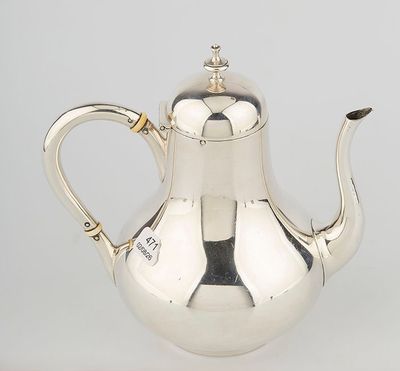 a silver tea pot with a handle and a handle on a white surface
