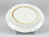an image of a white plate with a gold rim sitting on a stand