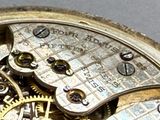 a close up of a pocket watch with gears on it
