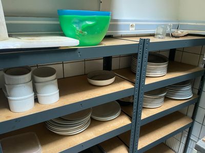 beaucoup d'assiettes et de bols sur les étagères de la cuisine