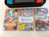 three nintendo wii games on the table next to a case