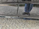 a reflection of a person standing in the reflection of a car
