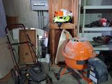 two lawn mowers and a lawn mower in a garage