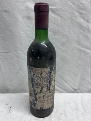 an old bottle of wine sitting on top of a white table
