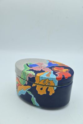 une image représentant une petite boîte bleue sur laquelle sont peintes des fleurs colorées