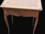 une petite table en bois avec un plateau en verre, sur fond noir