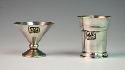two silver cups sitting next to each other on a table